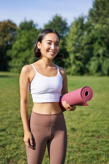 Retrato de una mujer joven haciendo ejercicio en el parque