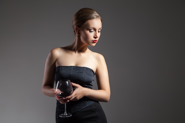 Retrato de mujer joven hermosa con copa de vino, estilización retro