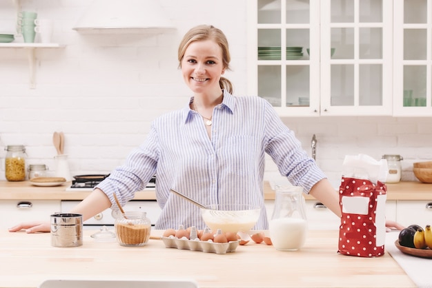 Retrato de mujer joven hermosa desayunando en la cocina.