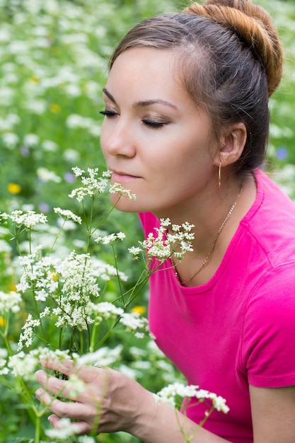 Retrato de mujer joven hermosa con flores en la naturaleza en verano