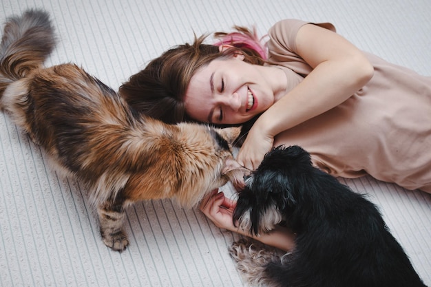 Retrato de una mujer joven y hermosa con un gato y un perro juntos