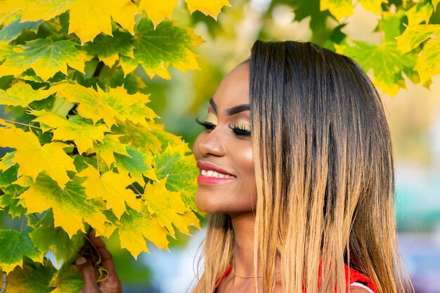 Retrato de mujer joven hermosa en hojas de otoño