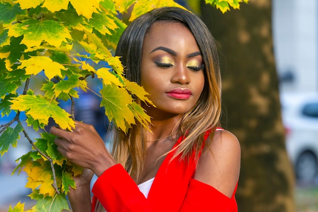 Retrato de mujer joven hermosa en hojas de otoño