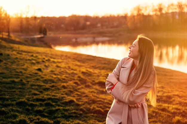 Retrato de mujer joven hermosa en la luz del sol fuera de Sunset ra