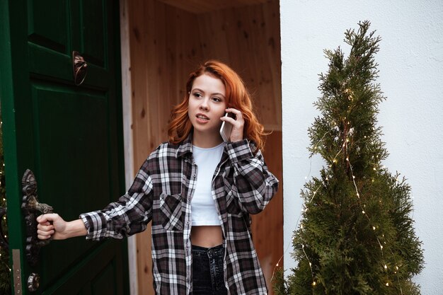 Retrato de mujer joven hermosa con el pelo rojo al aire libre.