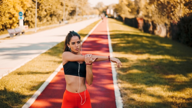 Foto retrato de la mujer joven hermosa que ejercita en el parque.