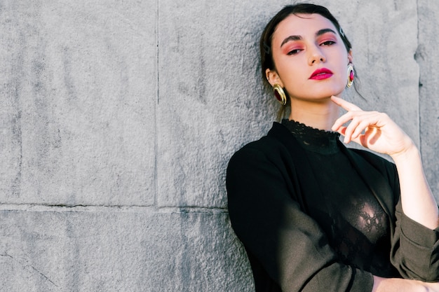 Foto retrato de una mujer joven hermosa que se inclina en la pared