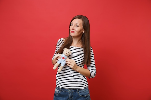 Retrato de mujer joven hermosa sonriente en ropa casual a rayas con osito de peluche de juguete