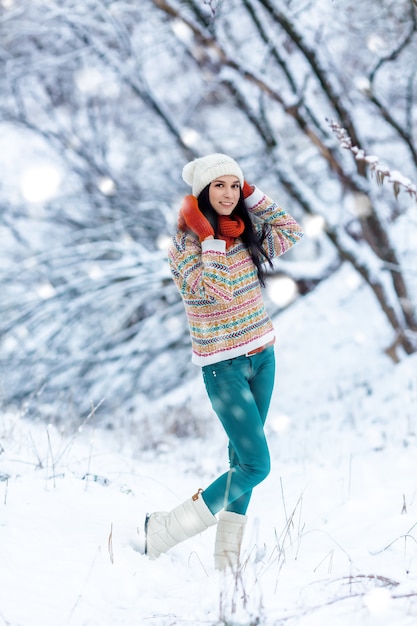 Retrato de mujer joven de invierno. Belleza alegre modelo chica riendo y divirtiéndose en el parque de invierno