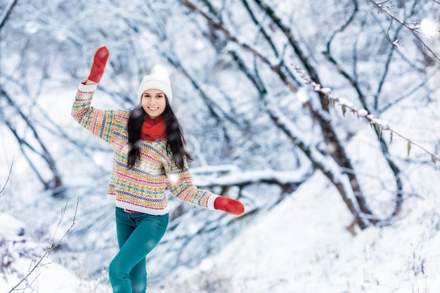 Retrato de mujer joven de invierno. Belleza alegre modelo chica riendo y divirtiéndose en el parque de invierno