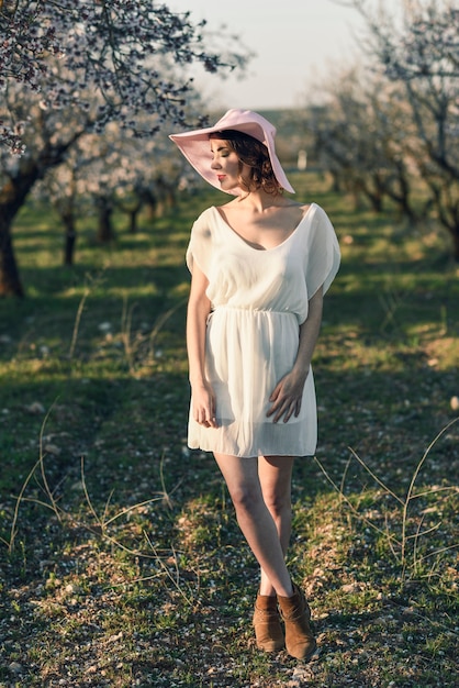 Retrato de mujer joven en el jardín de flores en el tiempo de primavera