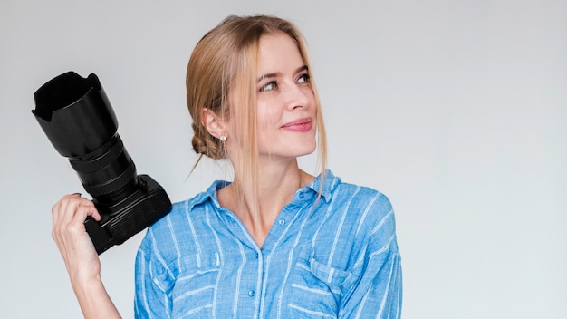 Foto retrato de mujer joven linda con una cámara