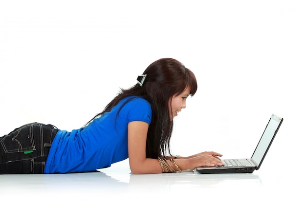 Retrato de una mujer joven linda que usa la computadora portátil