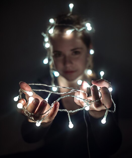 Foto retrato de una mujer joven con luces iluminadas