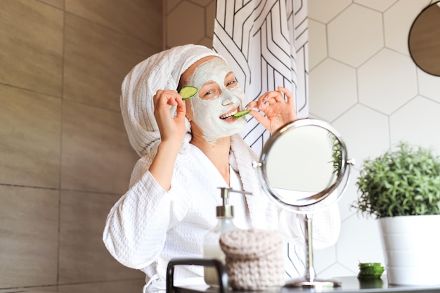 Retrato de mujer joven con máscara cosmética en la cara haciendo tratamientos de belleza antienvejecimiento en casa.