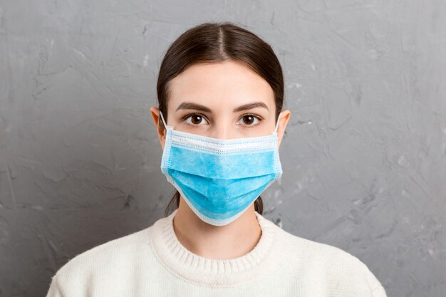 Retrato de mujer joven con máscara médica. Protege tu salud. Concepto de coronavirus