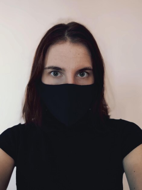 Foto retrato de una mujer joven con una máscara negra