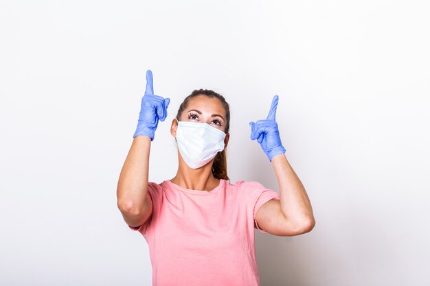 . Retrato de mujer joven con mascarilla aparece con sus dedos. Concepto de prevención Covid-19