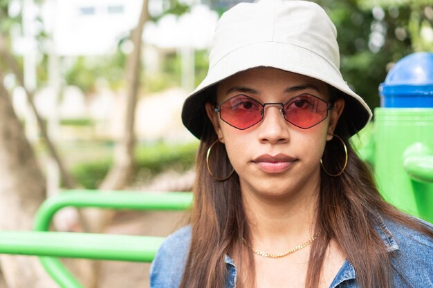 retrato, de, mujer joven, mirar cámara del juez, en, rojo, gafas de sol