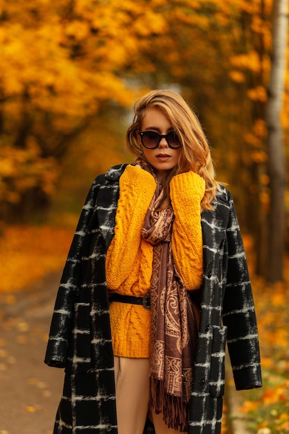 Retrato de mujer joven de moda al aire libre en el fondo del parque de otoño