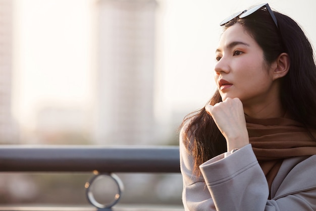 Foto retrato de mujer joven mujer tailandesa de compras por la noche, estilo de vida para mujer caminar en la puesta de sol junto al río, retrato sincero mujer bangkok, tailandia, asia.