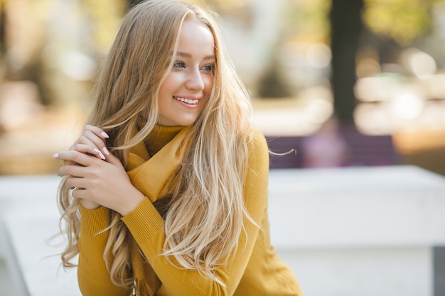 Retrato de mujer joven muy atractiva al aire libre. Hermosa dama rubia en el fondo urbano. Elegante retrato de primer plano femenino.