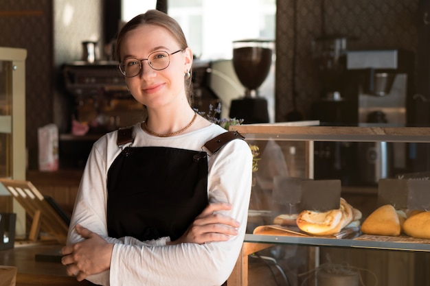 Retrato de mujer joven muy sonriente propietario o camarera en el café