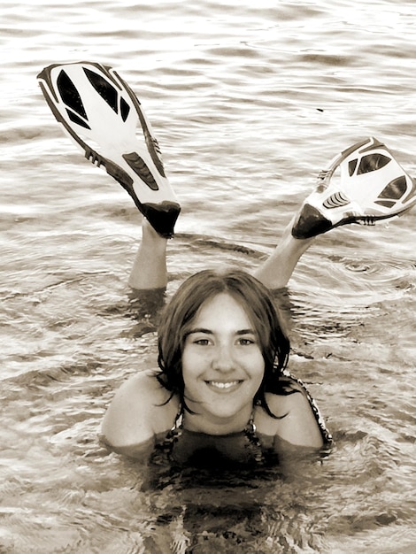 Foto retrato de una mujer joven nadando en el mar