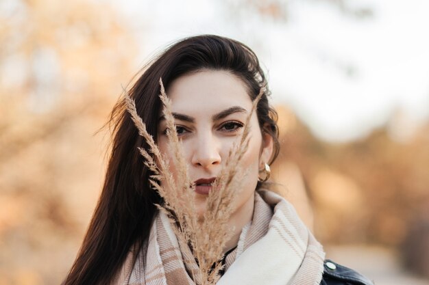 Retrato de una mujer joven en otoño en el parque