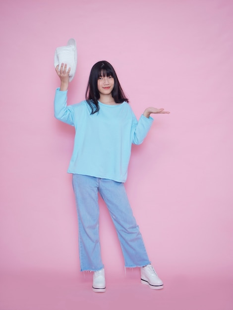 Retrato de mujer joven en pared rosa