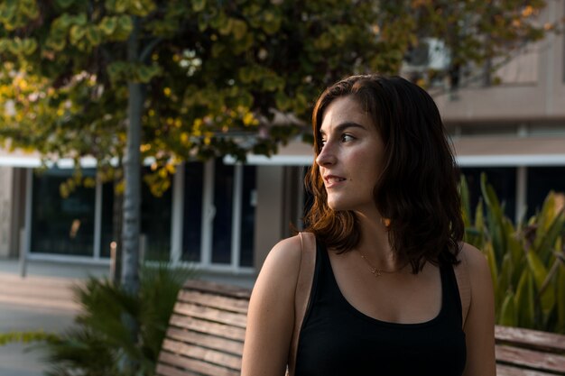 Retrato de una mujer joven en un parque de una ciudad