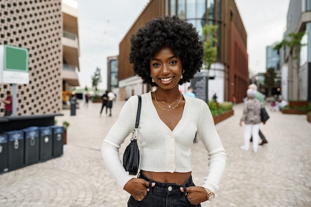 retrato, de, mujer joven, con, peinado, sonriente, en, urbano, plano de fondo