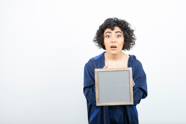 Retrato de una mujer joven con pelo rizado con marco de pie.