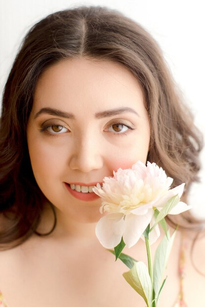 Retrato de una mujer joven con peonía flor