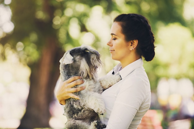 Retrato de mujer joven con perro al aire libre