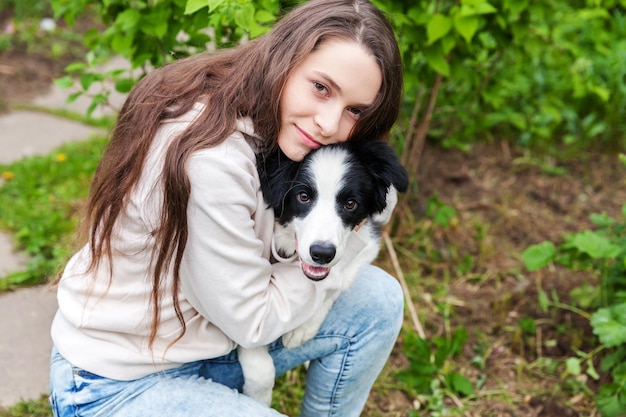 Foto retrato de una mujer joven con un perro en el campo