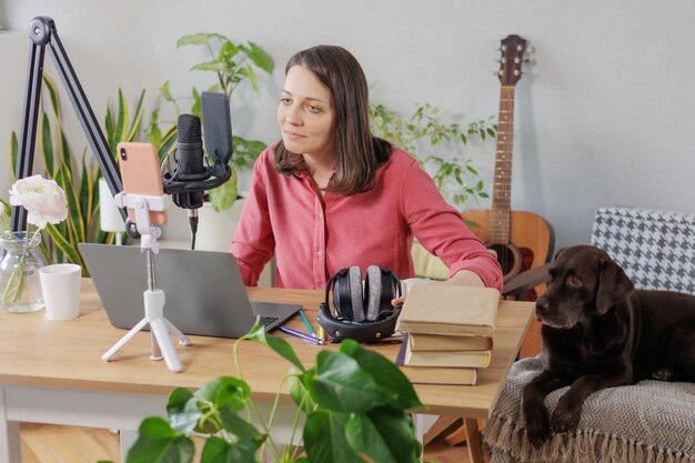 Foto retrato de una mujer joven con un perro sentado en casa