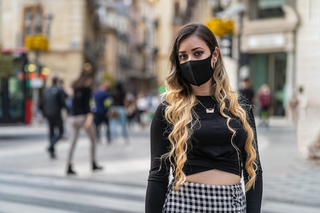 Foto retrato de una mujer joven de pie en la calle de la ciudad