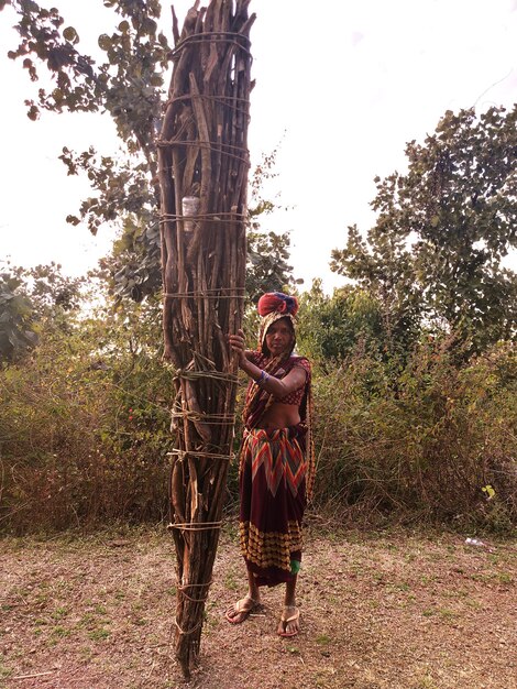 Foto retrato de una mujer joven de pie en el campo