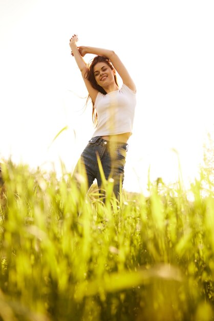 Foto retrato de una mujer joven de pie en el campo