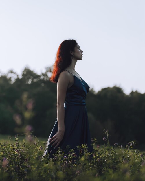 Foto retrato de una mujer joven de pie en el campo