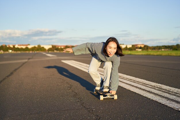 Foto retrato de una mujer joven de pie en la carretera contra el cielo