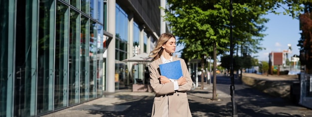 Foto retrato de una mujer joven de pie en la ciudad