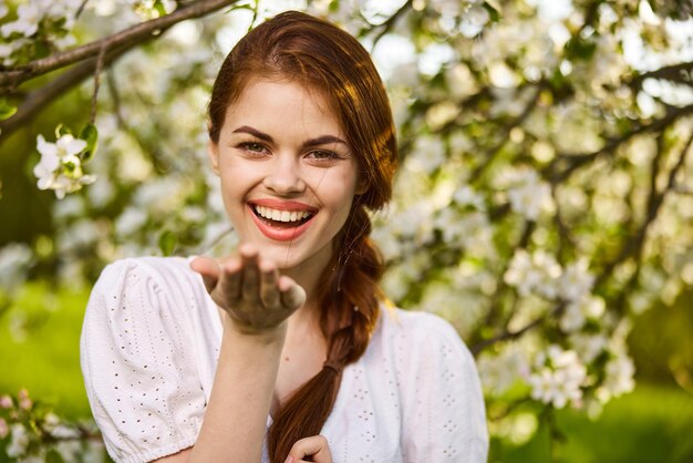 Foto retrato de una mujer joven de pie contra un árbol