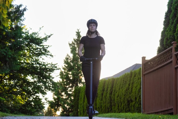 Foto retrato de una mujer joven de pie contra los árboles