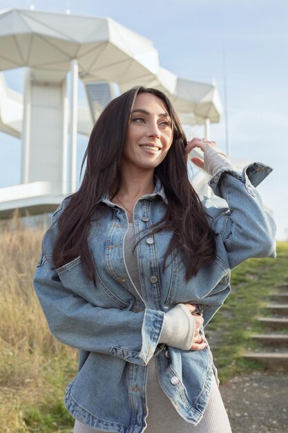 Foto retrato de una mujer joven de pie contra los árboles