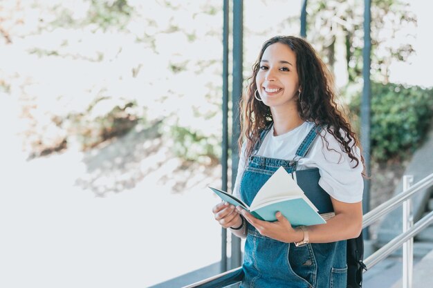 Foto retrato de una mujer joven de pie contra los árboles