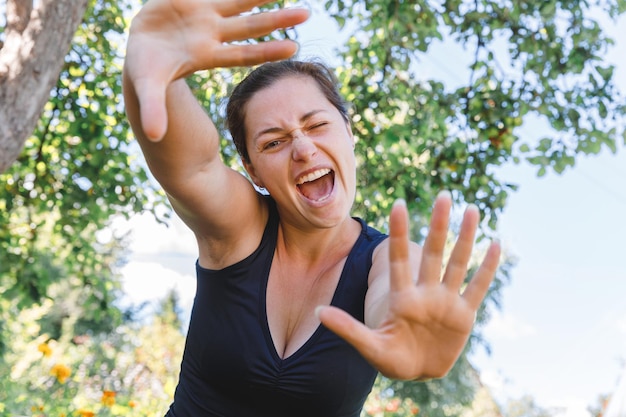 Foto retrato de una mujer joven de pie contra los árboles