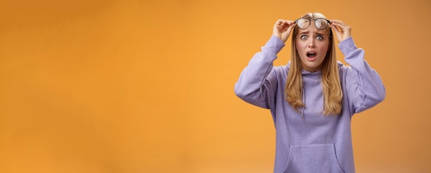 Retrato de una mujer joven de pie contra un fondo amarillo