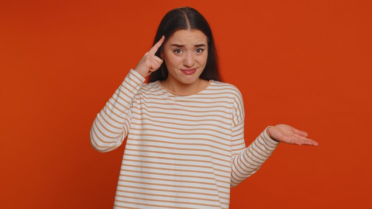 Foto retrato de una mujer joven de pie contra un fondo amarillo
